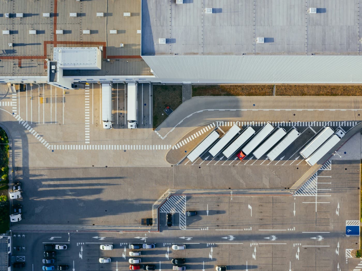 Aerial view of a distribution building, its dock doors, and a truck court of trailers