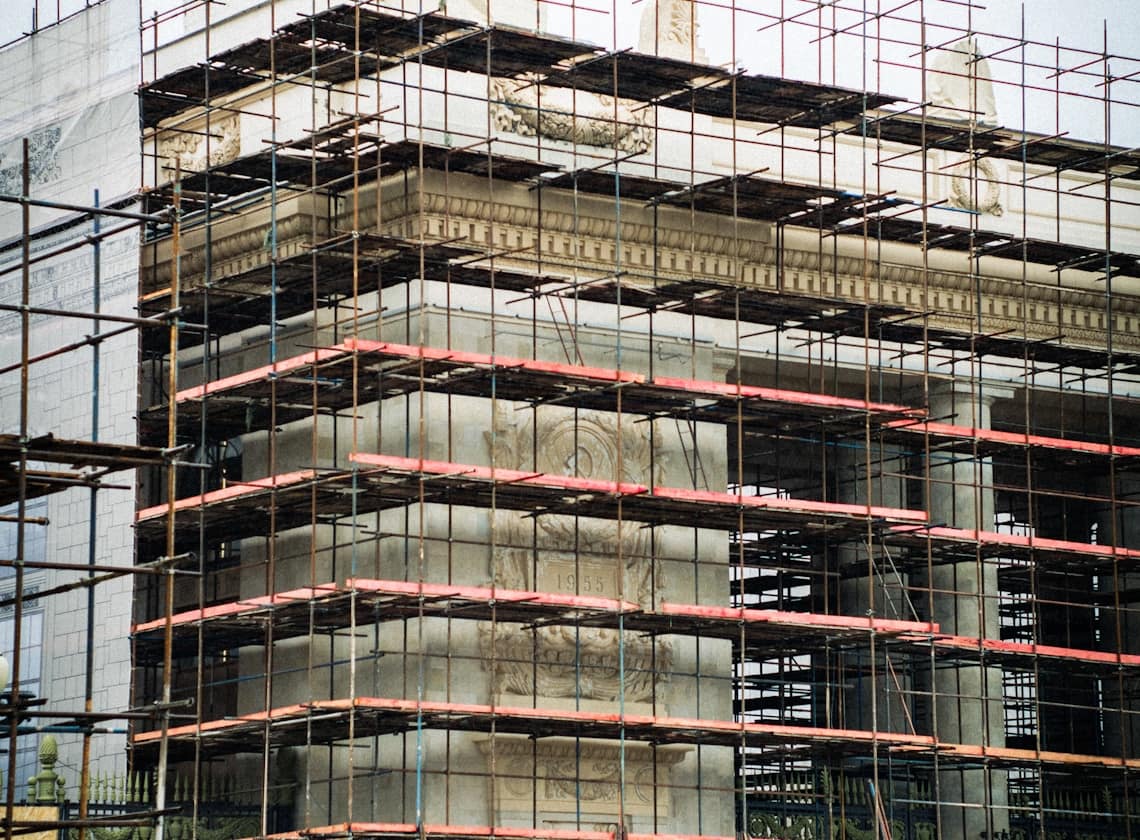 A commercial building under restoration behind full scaffolding